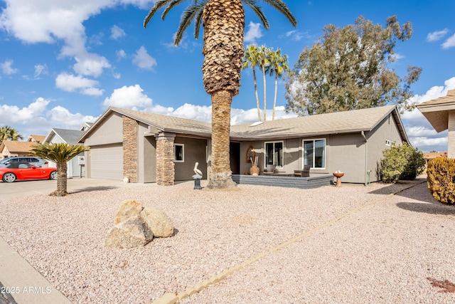 single story home featuring stone siding, concrete driveway, an attached garage, and stucco siding