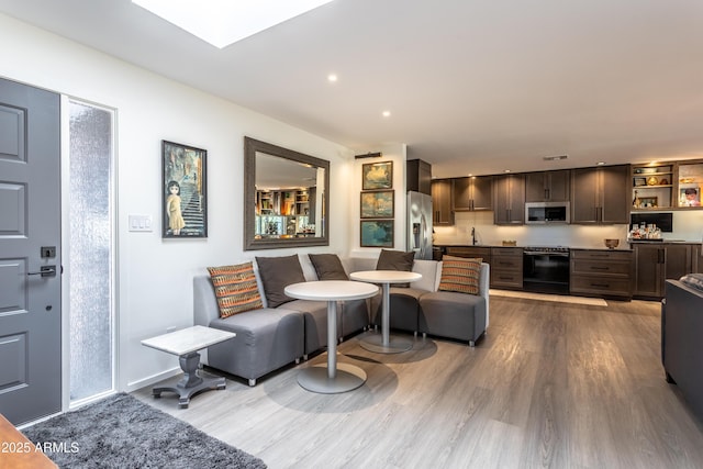 living room featuring hardwood / wood-style floors and sink