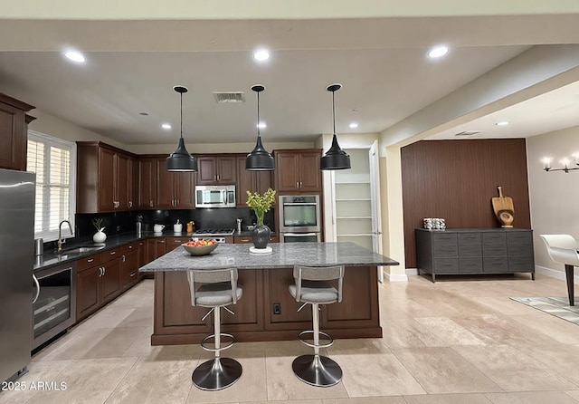 18515 N 94th St, Scottsdale, AZ 85255 - kitchen with stainless steel appliances, a sink, a kitchen island, decorative backsplash, and a breakfast bar area