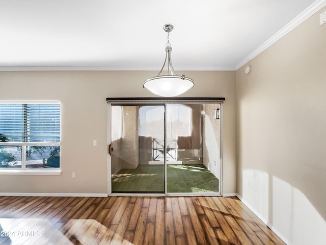 doorway featuring a wealth of natural light, crown molding, and hardwood / wood-style flooring