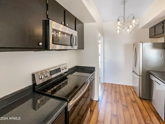 kitchen featuring light hardwood / wood-style flooring, stainless steel appliances, decorative light fixtures, and a notable chandelier