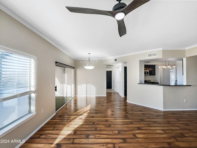 unfurnished living room featuring crown molding, dark hardwood / wood-style flooring, and ceiling fan with notable chandelier