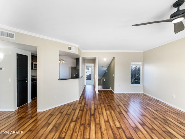 unfurnished living room featuring crown molding, ceiling fan with notable chandelier, and dark hardwood / wood-style floors