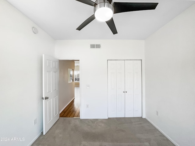 unfurnished bedroom with ceiling fan, carpet floors, and a closet