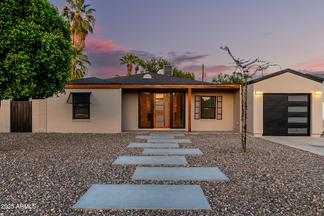 view of front of house with fence, an attached garage, and concrete driveway
