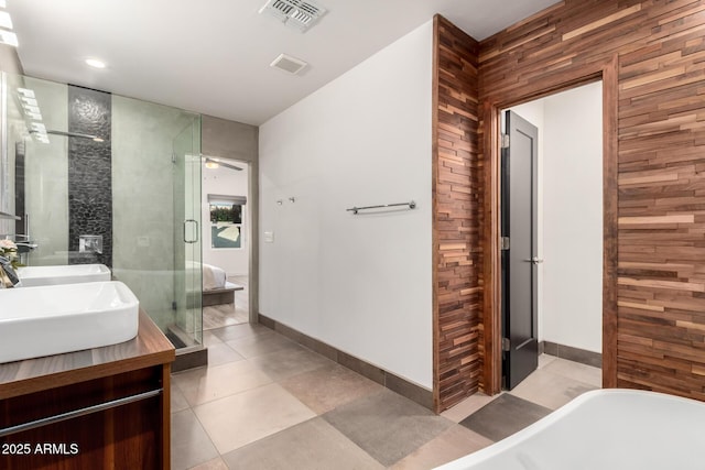 bathroom featuring visible vents, a freestanding tub, wooden walls, and vanity