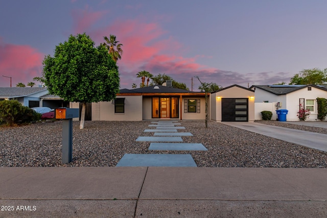 view of front of home with an attached garage, stucco siding, and driveway