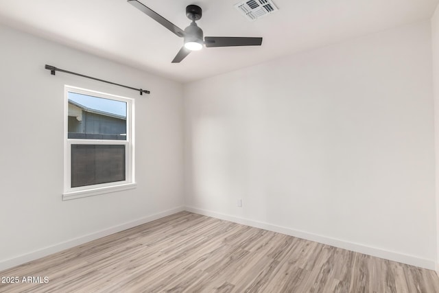 unfurnished room featuring visible vents, a ceiling fan, light wood finished floors, and baseboards