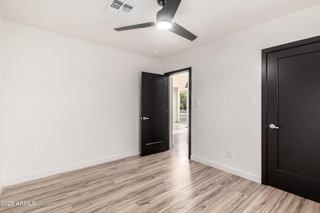 unfurnished bedroom featuring baseboards, visible vents, ceiling fan, and light wood-style floors