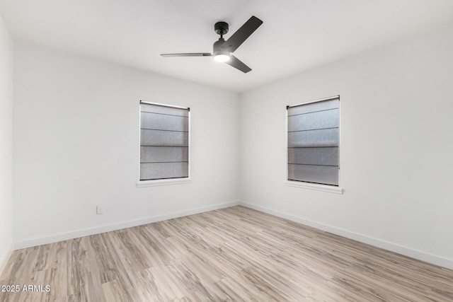 spare room with a ceiling fan, baseboards, and wood finished floors