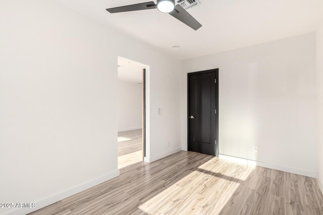 unfurnished bedroom with baseboards, light wood finished floors, ceiling fan, and visible vents