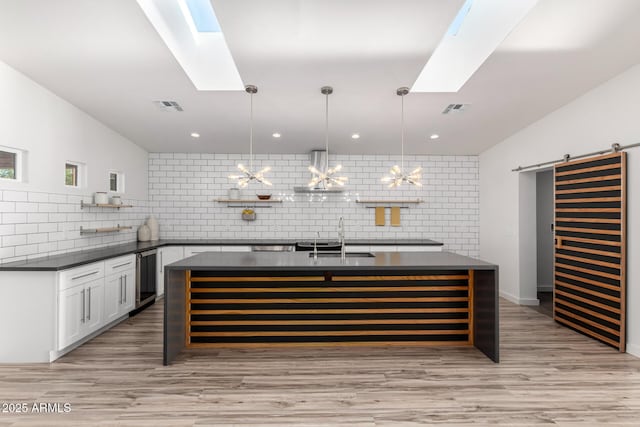 bar with a skylight, tasteful backsplash, a barn door, and a sink