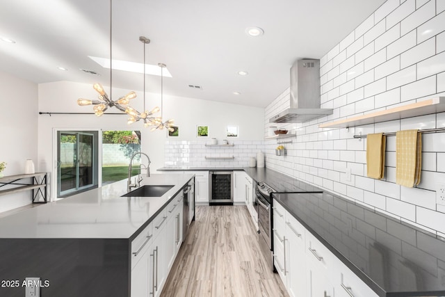 kitchen with open shelves, appliances with stainless steel finishes, ventilation hood, a sink, and beverage cooler