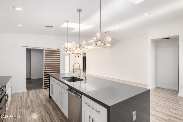 kitchen with visible vents, dark countertops, stainless steel dishwasher, a sink, and a chandelier