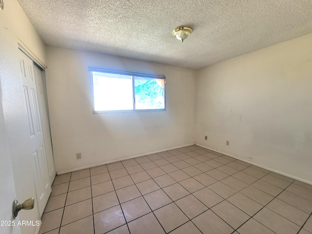 15602 N 55th Ave, Glendale, AZ 85306 - unfurnished bedroom with a textured ceiling, a closet, and light tile patterned flooring