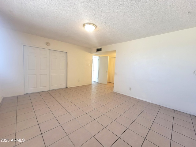 15602 N 55th Ave, Glendale, AZ 85306 - unfurnished bedroom featuring a textured ceiling, a closet, and light tile patterned flooring