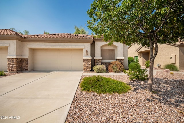 1560 E Melrose Dr, Casa Grande, AZ 85122 - view of front facade with stone siding, driveway, a tiled roof, an attached garage, and stucco siding