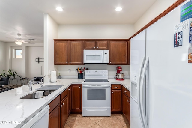 kitchen with light stone countertops, sink, white appliances, ceiling fan, and light tile patterned flooring