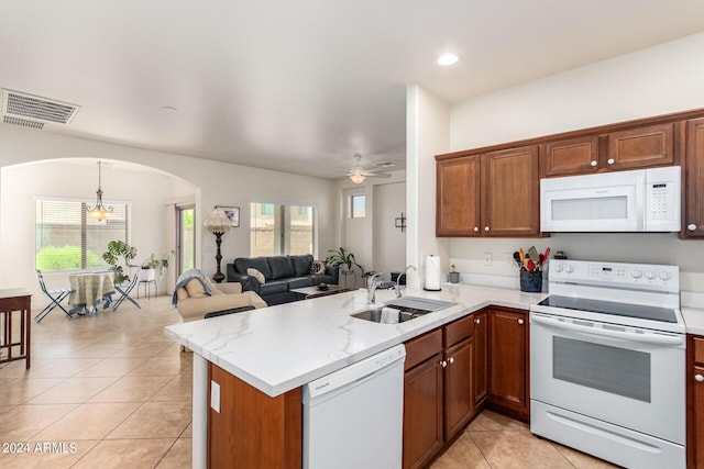 kitchen featuring white appliances, light tile patterned floors, sink, and kitchen peninsula