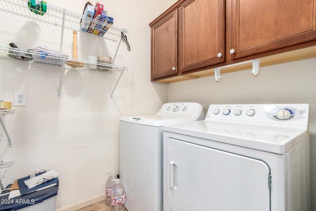 laundry room with cabinets and washing machine and clothes dryer