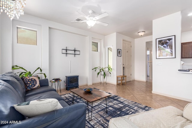 living room featuring a wood stove, light tile patterned flooring, and ceiling fan