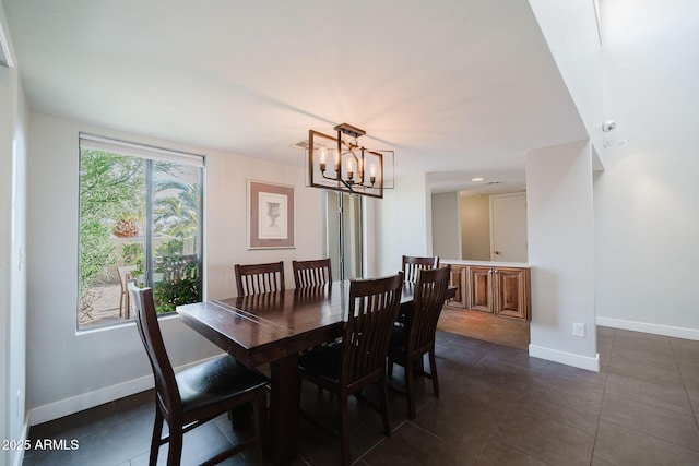 dining room featuring a notable chandelier, dark tile patterned floors, and baseboards