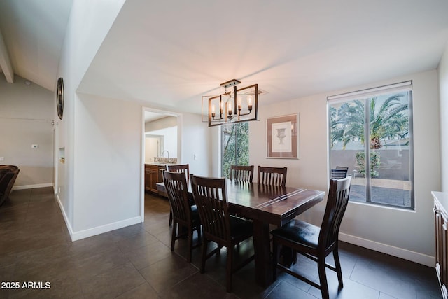 dining room featuring dark tile patterned floors, baseboards, and a healthy amount of sunlight