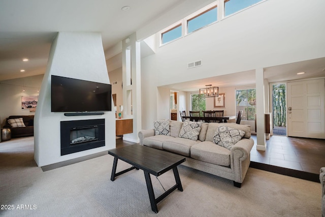 living area with recessed lighting, carpet floors, a chandelier, a glass covered fireplace, and visible vents