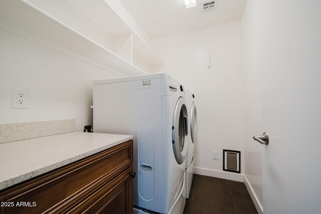 washroom featuring laundry area, dark tile patterned floors, washing machine and clothes dryer, baseboards, and visible vents
