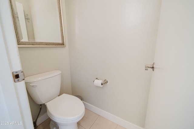 bathroom with toilet, tile patterned flooring, and baseboards