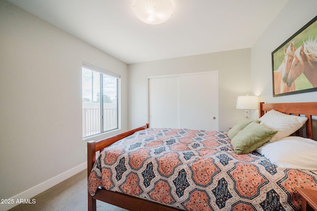 carpeted bedroom with baseboards and a closet