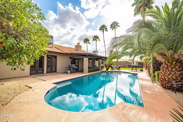 view of pool featuring fence, a patio area, french doors, and a fenced in pool