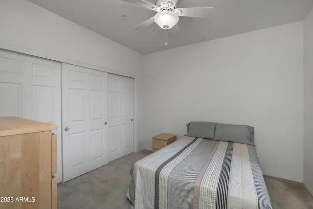 bedroom with ceiling fan, light colored carpet, and a closet