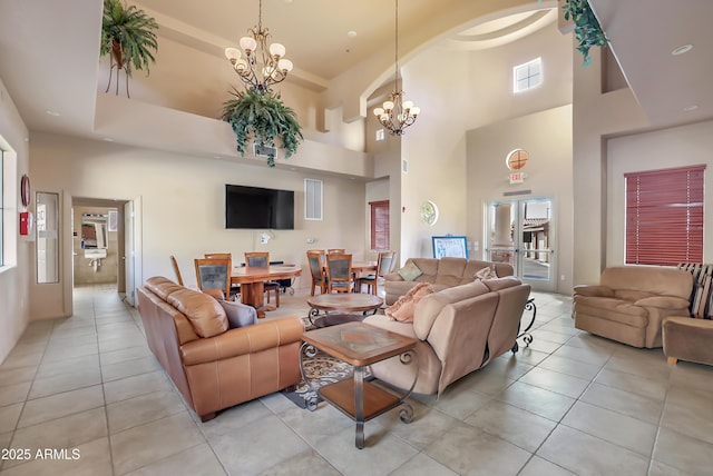 living room featuring light tile patterned floors, a notable chandelier, and a high ceiling