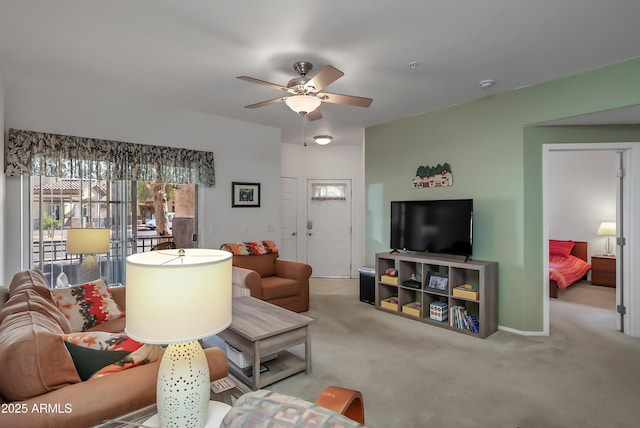 carpeted living room with ceiling fan