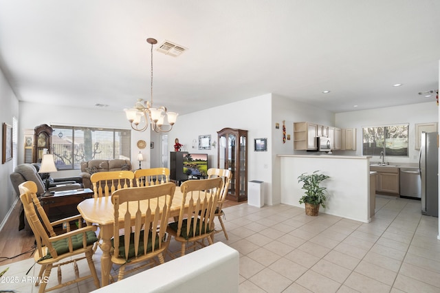 dining space featuring an inviting chandelier, light tile patterned flooring, and sink