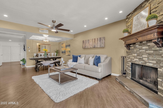 living room featuring a fireplace, wood-type flooring, and ceiling fan