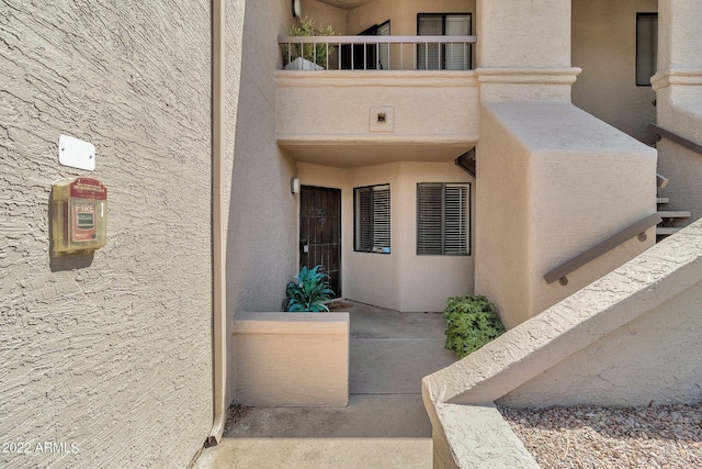 view of exterior entry with a balcony