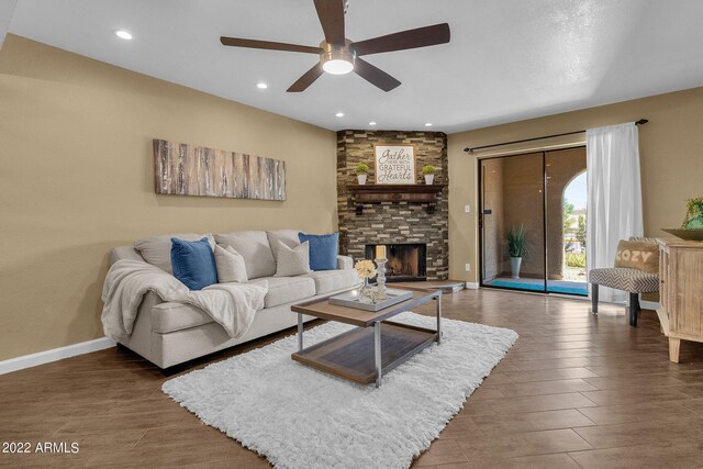 living room featuring ceiling fan and a fireplace