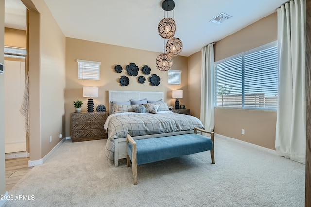 bedroom with visible vents, light carpet, and baseboards