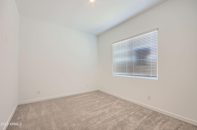 carpeted empty room featuring baseboards