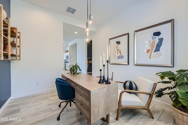 office space featuring light wood-type flooring, visible vents, and baseboards