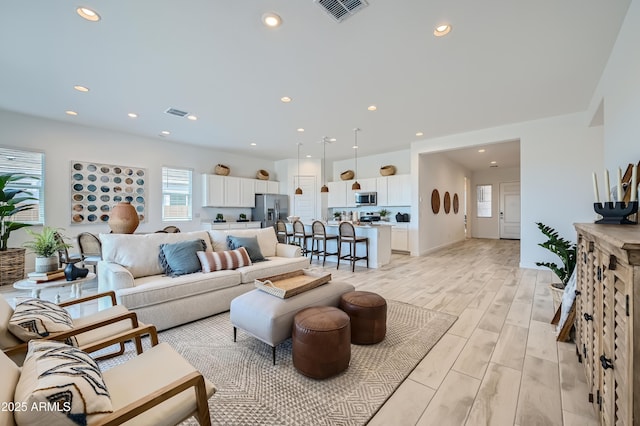 living area featuring visible vents, recessed lighting, and wood finish floors