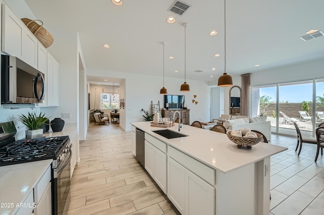 kitchen featuring visible vents, appliances with stainless steel finishes, light countertops, and a sink