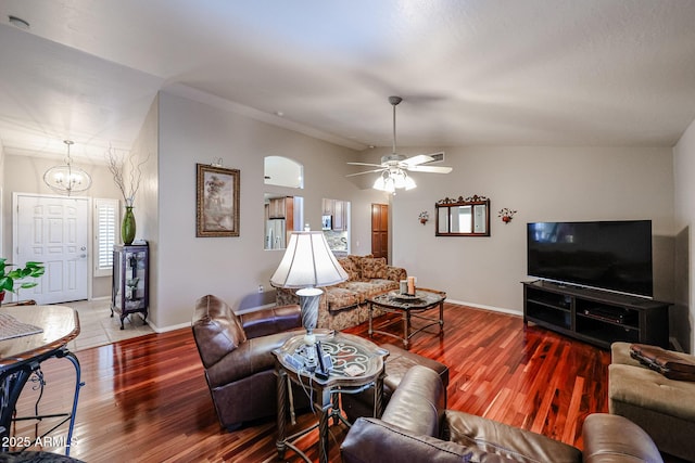 living room featuring vaulted ceiling, hardwood / wood-style floors, and ceiling fan with notable chandelier