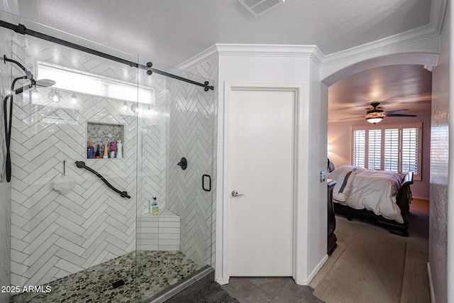 bathroom featuring tile patterned floors, ceiling fan, a shower with door, and ornamental molding