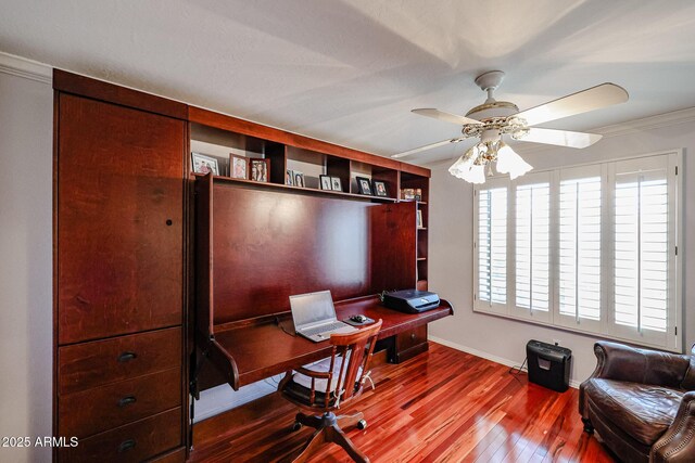 home office featuring ceiling fan, wood-type flooring, and crown molding