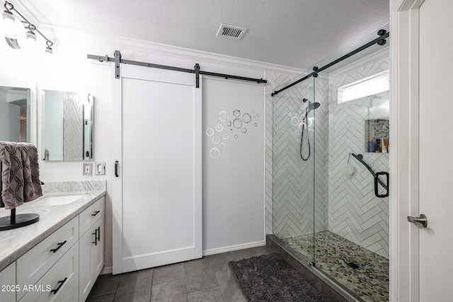 bathroom with tile patterned flooring, crown molding, an enclosed shower, a textured ceiling, and vanity