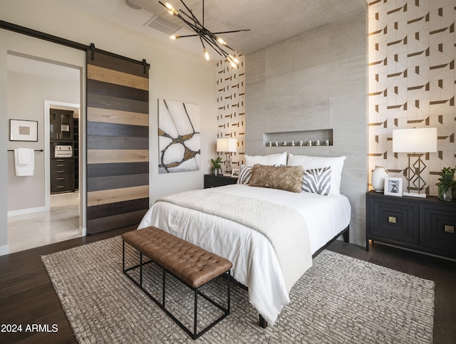 bedroom with a barn door and dark hardwood / wood-style floors