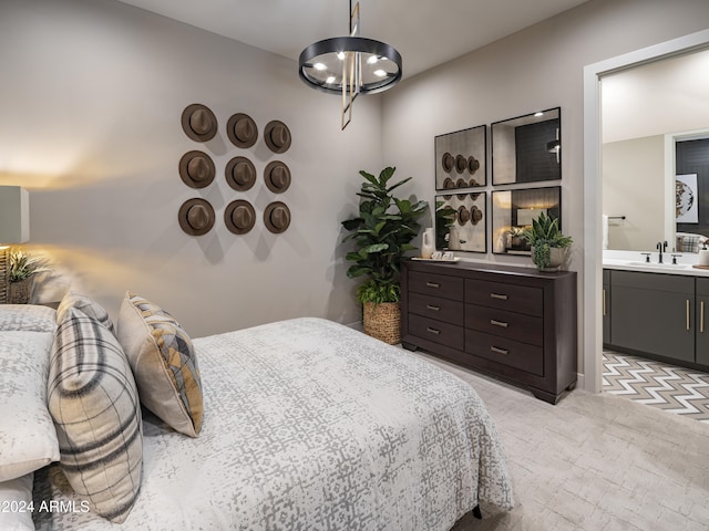 carpeted bedroom featuring ensuite bathroom, sink, and a chandelier